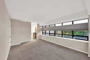 Empty room with light carpet and baseboards