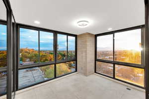 Spare room with a wall of windows, light tile patterned floors, a mountain view, and recessed lighting