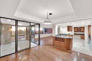 Unfurnished dining area with recessed lighting, light wood finished floors, and a raised ceiling