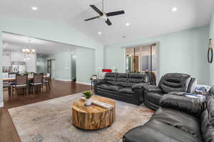 Living area with a ceiling fan, a chandelier, wood finished floors, recessed lighting, and vaulted ceiling