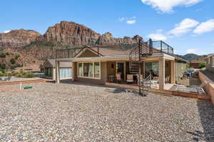 Rear view of property with a mountain view, a patio, and a balcony
