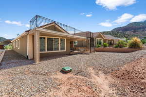 Back of property with stairs, a mountain view, and a patio area