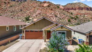 View of front of house featuring board and batten siding, a mountain view, driveway, and an attached garage