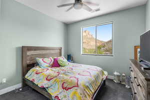 Bedroom with dark carpet and a ceiling fan