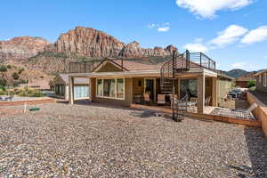 Rear view of house with a mountain view, a patio area, stairway, and stucco siding