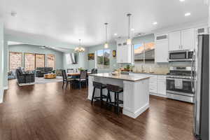 Kitchen featuring stainless steel appliances, plenty of natural light, white cabinetry, a kitchen island, and recessed lighting