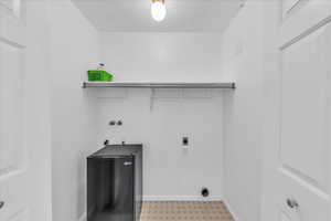 Laundry area featuring electric dryer hookup, light floors, and washer hookup