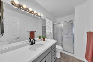 Full bath with vanity, a stall shower, and tile patterned floors