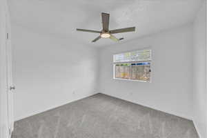 Unfurnished room featuring carpet flooring and ceiling fan
