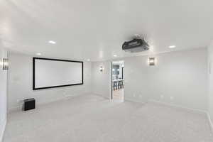 Home theater room with recessed lighting and carpet floors