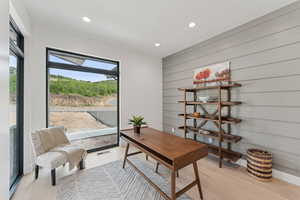 Office area featuring recessed lighting, light wood-style floors, and wooden walls