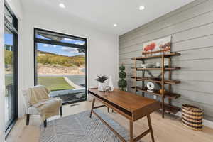 Office space featuring light wood-style floors, recessed lighting, and wooden walls