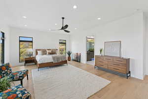 Bedroom with recessed lighting, ceiling fan, light wood finished floors, and ensuite bath