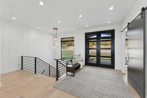 Entrance foyer featuring a barn door, light wood-style flooring, and recessed lighting