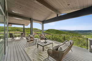 Wooden terrace with an outdoor living space, a mountain view, and outdoor dining space