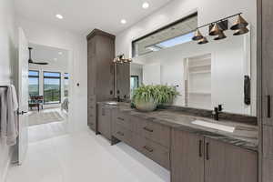 Ensuite bathroom with double vanity, ceiling fan, recessed lighting, and a closet
