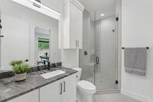 Bathroom featuring vanity, tile patterned flooring, a shower stall, and recessed lighting