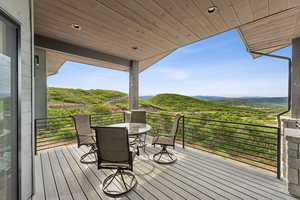 Wooden deck featuring outdoor dining space and a mountain view