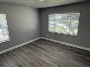 Spare room featuring wood finished floors and a textured ceiling