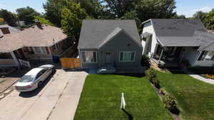 View of front of house featuring a front lawn and roof with shingles