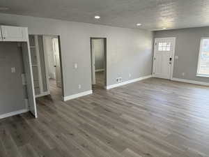 Entrance foyer with a textured ceiling, light wood-style floors, and recessed lighting
