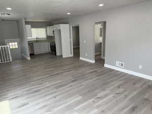 Unfurnished living room featuring light wood finished floors, recessed lighting, and a textured ceiling