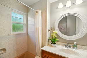 Full bath with a shower with curtain and vanity