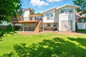 Rear view of house with a wooden deck, stairway, and board and batten siding