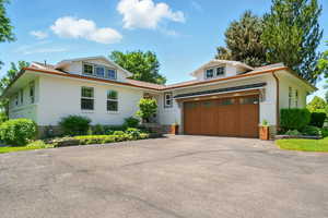 View of front facade with brick siding, asphalt driveway, and a garage