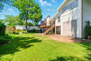 View of yard featuring stairway, a wooden deck, and a patio