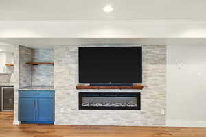 Detailed view of wine cooler, crown molding, and wood finished floors