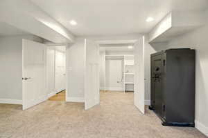 Unfurnished bedroom with light carpet, recessed lighting, and a spacious closet
