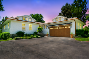 View of front of house featuring driveway, brick siding, and a garage