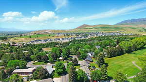 Aerial view of property's location with a mountainous background and nearby suburban area