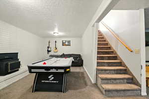 Recreation room with a textured ceiling and carpet floors