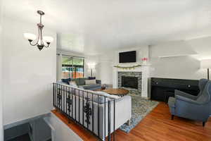 Living area featuring wood finished floors, a fireplace, and a textured ceiling