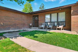 Property entrance with brick siding and a yard