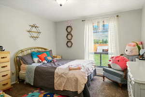 Carpeted bedroom featuring a textured ceiling