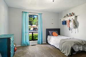 Bedroom with carpet and a textured ceiling