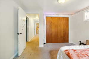 Bedroom featuring light colored carpet and a closet
