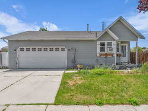 View of front of house with concrete driveway, a garage, and roof with shingles