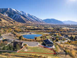 Aerial view of property and surrounding area featuring property parcel outlined and a water and mountain view