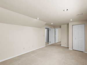 Unfurnished bedroom with light colored carpet, recessed lighting, a textured ceiling, and a closet
