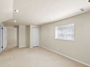 Unfurnished bedroom featuring light carpet, recessed lighting, and a textured ceiling