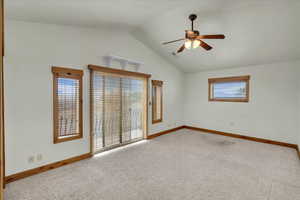 Carpeted spare room with lofted ceiling and ceiling fan