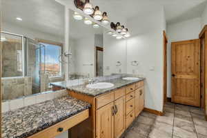 Full bath featuring double vanity and a stall shower