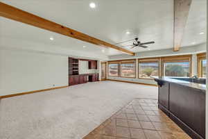 Unfurnished living room featuring light colored carpet, recessed lighting, beamed ceiling, and a ceiling fan