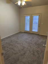Carpeted empty room featuring ceiling fan and baseboards