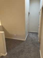 Hallway featuring carpet and baseboards