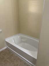 Full bathroom featuring a bath and tile patterned floors
